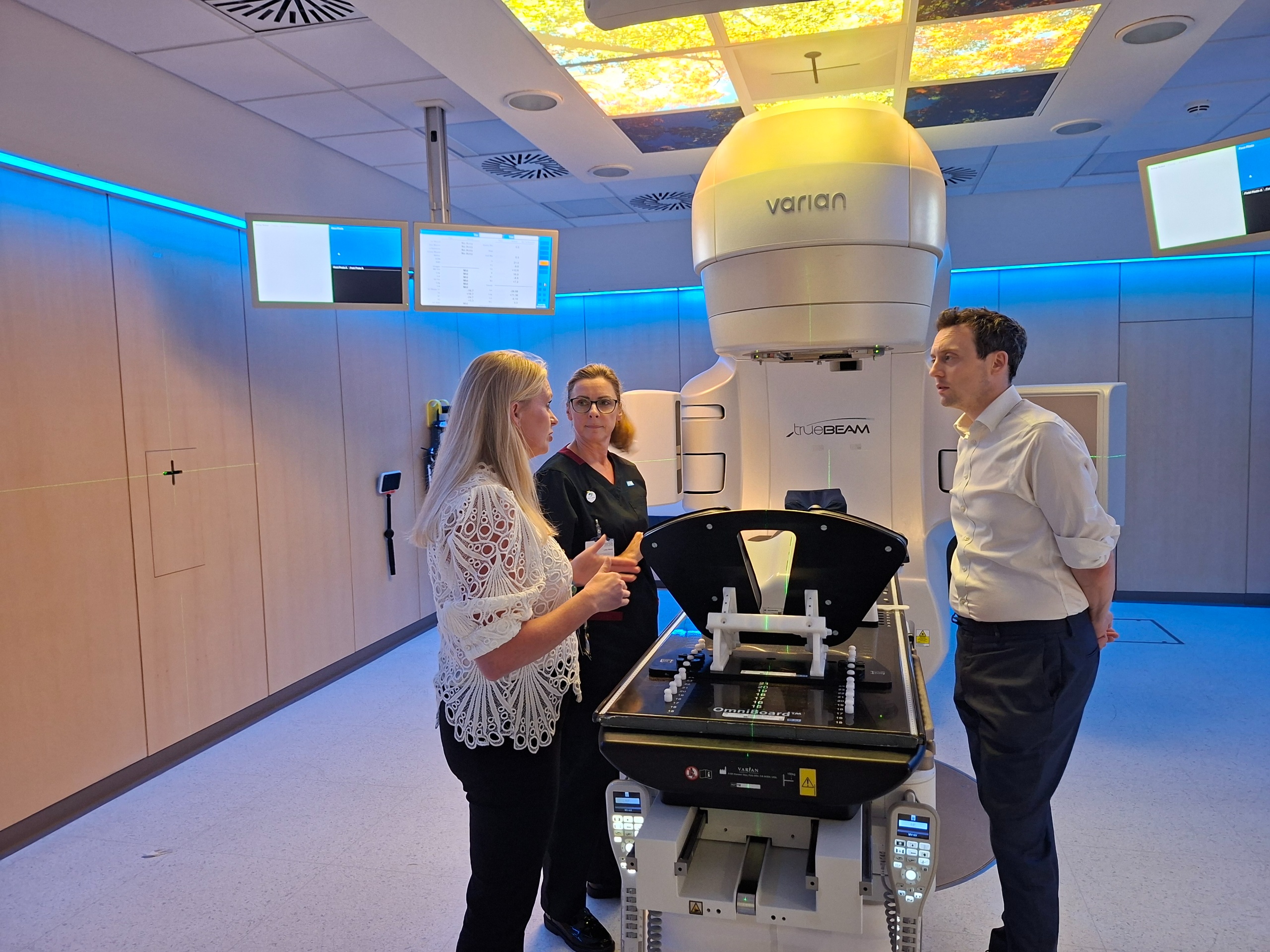 People looking at a radiotherapy treatment machine
