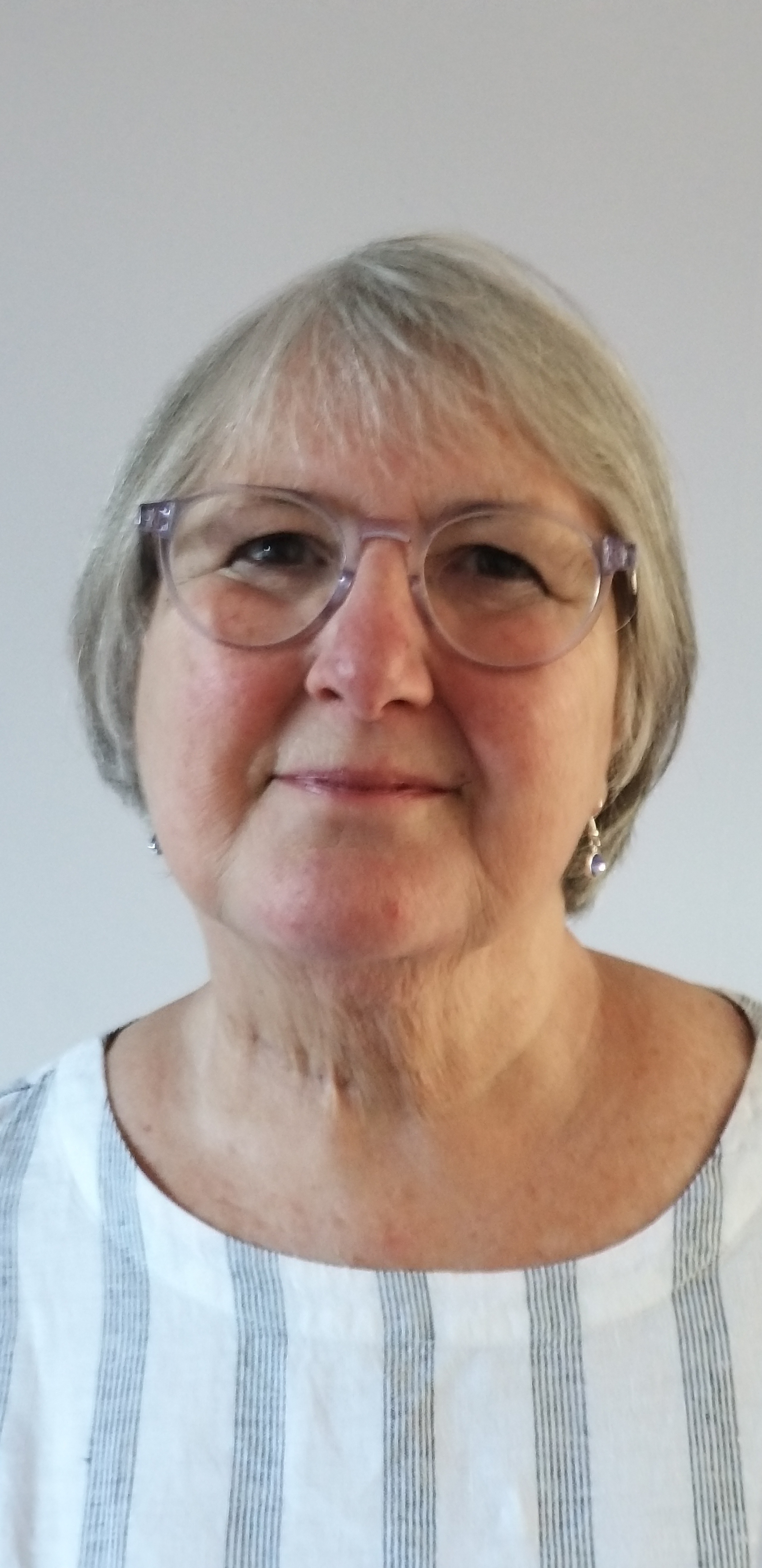 Picture of Dorothy who has grey hair in a short bob and is wearing glasses and smiling