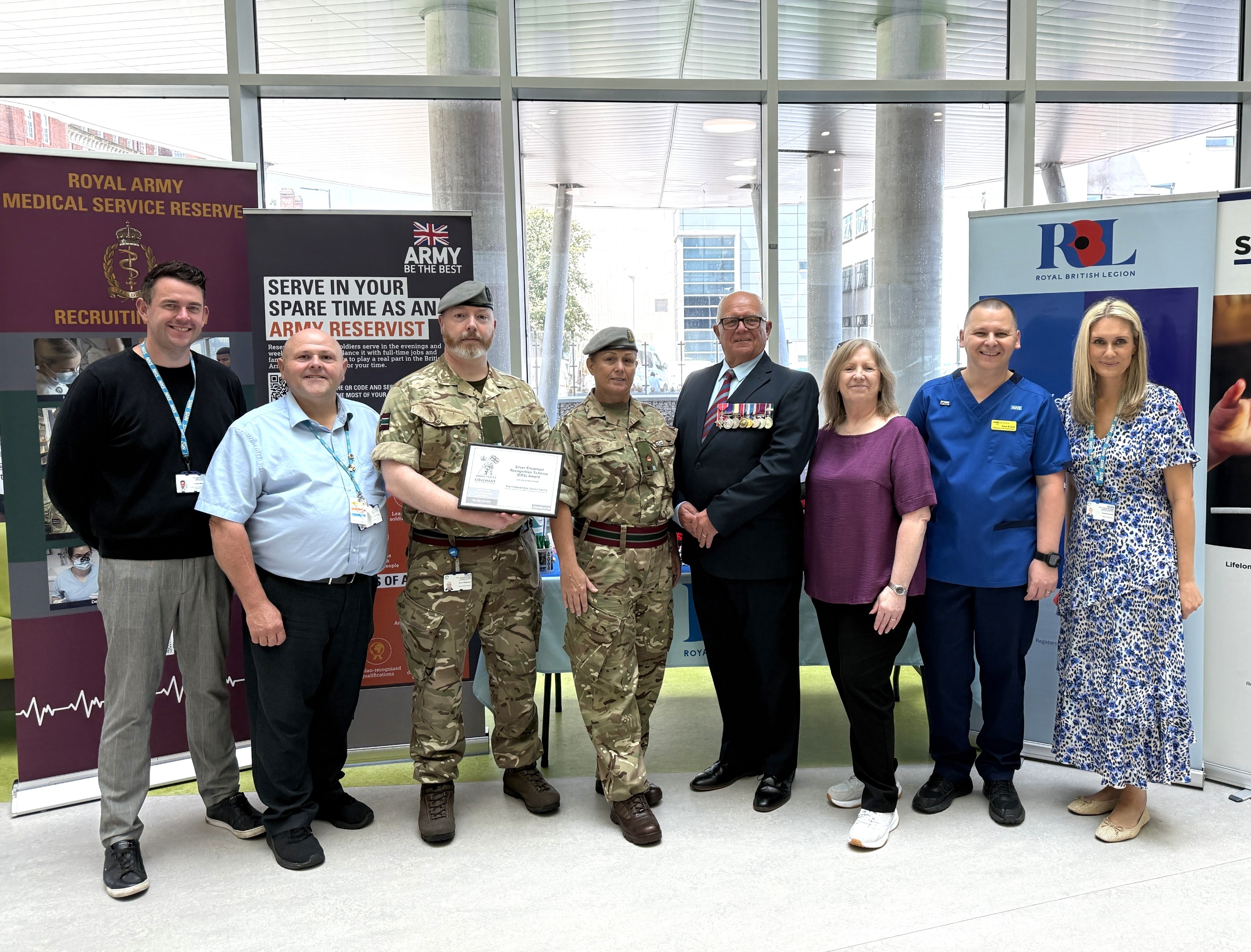 Members of staff and the CCC Armed Forces Network stood in row holding a certificate