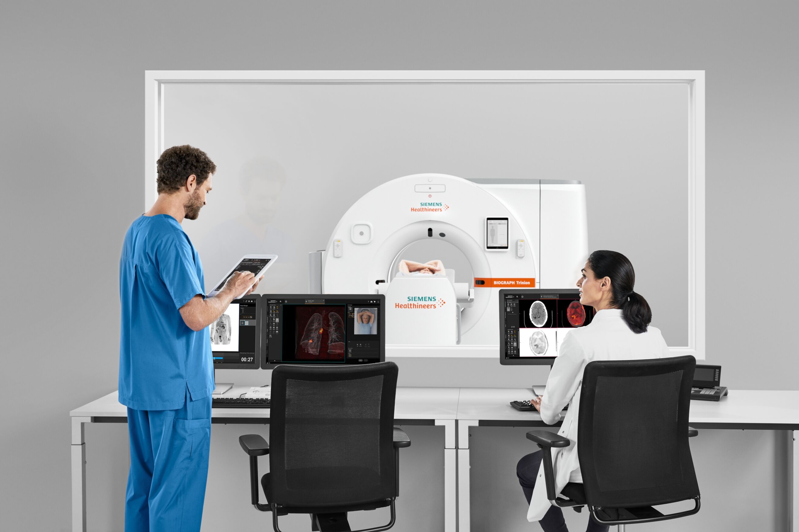 Two clinical staff members at the control desk for a scanner