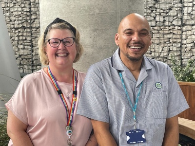 Female nurse and male nurse pictured in the outdoor winter garden. They are smiling