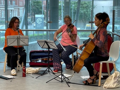Trio of musicians playing clarinet, viola and cello in hospital