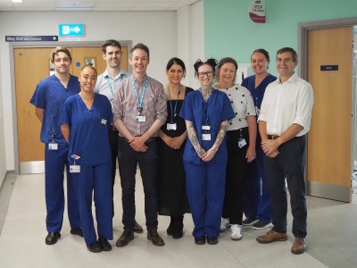 The team involved in the AI brachytherapy project stand together in a hospital corridor.